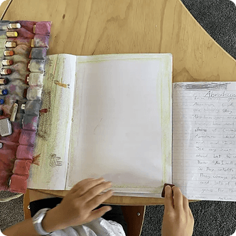 Child working with notebook and art supplies at home