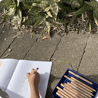 Child drawing with colored pencils in notebook
